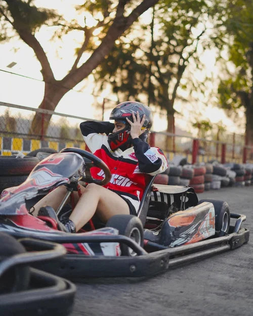 Person in a go-kart with a helmet on a track